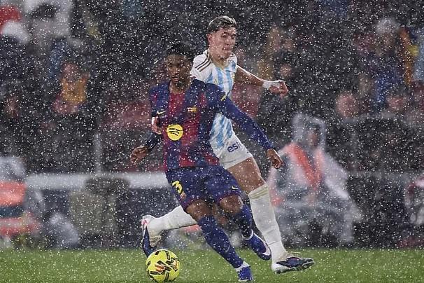 暴雨倾泻进诺坎普球场，记者纷纷在媒体席上撑起雨伞工作